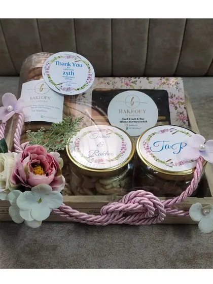 A special return hamper to celebrate 25 years of love. This elegant wooden tray hamper was filled with our assorted chocolates, cookies, and dry fruit jars, all customized with personalized tags for the silver anniversary.