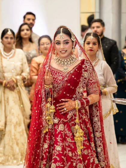 A closer portrait of the bride during her entrance, capturing her radiant smile and the intricate details of her wedding attire and jewelry.