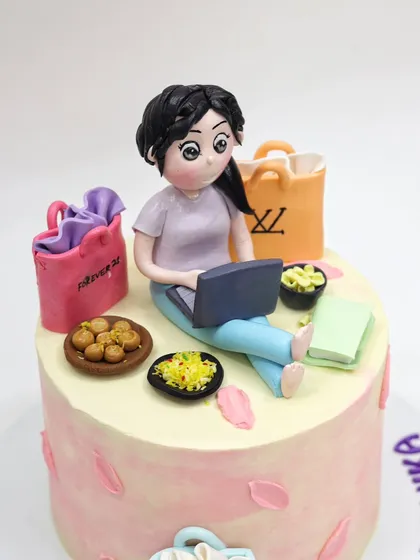 A close-up of the shopaholic figurine, multitasking with her laptop and snacks.