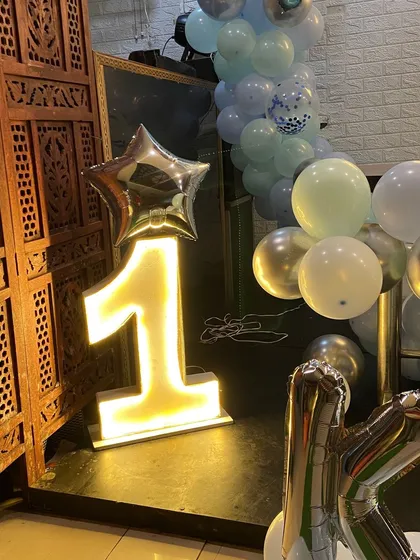 To make milestone birthdays stand out, I provide large, light-up marquee numbers. This glowing number '1' adds a professional and eye-catching element to a first birthday party, perfect for photos.