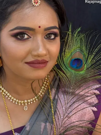 This creative shot with a peacock feather complements the purple and grey tones of the makeup and saree.