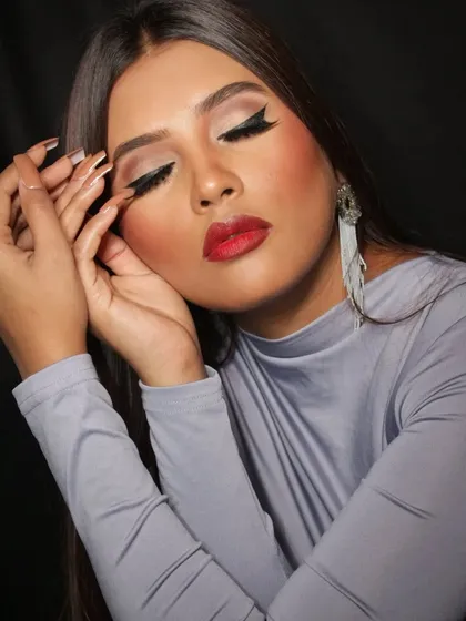 Eyes closed to show the clean, sharp winged eyeliner, a fundamental skill for any makeup artist.