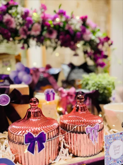 The rose-gold decorative jars with purple bow details are both beautiful and useful, making them a perfect addition to a new home.