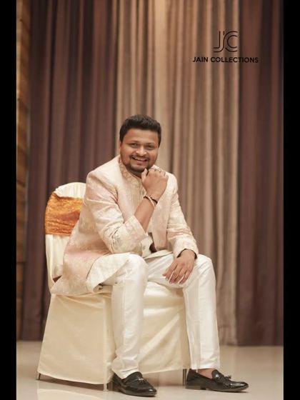 A happy client looking dapper in our pastel pink Jodhpuri suit. It's a great choice for a daytime event, offering a touch of color and elegance.