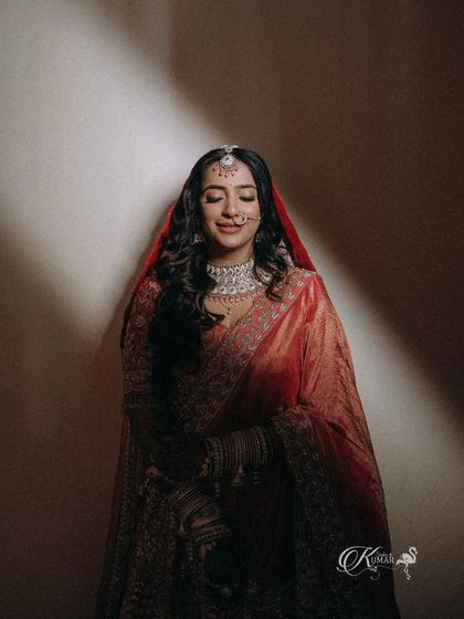 A serene bridal portrait, with the bride's eyes closed, under a soft, focused light.