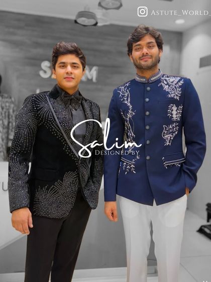 Two clients in contrasting styles. One wears a black tuxedo with cascading crystal work, while the other is in a blue Jodhpuri jacket with elegant white embroidery.