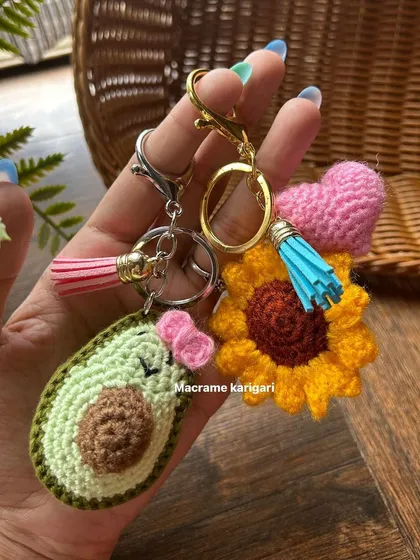 We love creating small, joyful things like these crochet keychains. Here you can see the detail in our cute avocado and sunflower designs, complete with little tassels. They are perfect for personalizing your bag or as a thoughtful handmade gift.