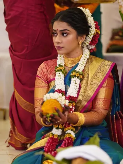 A moment of ritual and tradition. The bride's focused expression is beautifully captured, with her makeup looking flawless and her hair perfectly styled.