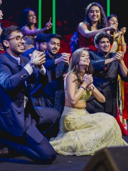 A candid moment of the bride and groom enjoying their friends' hilarious and heartfelt performance.