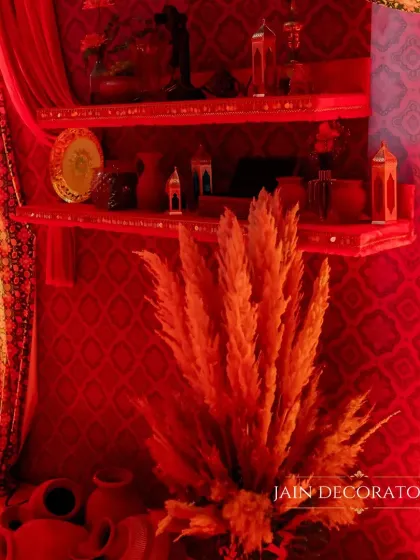 A moody and atmospheric shot of a decor corner. The red lighting and rustic props create a warm and inviting niche within the larger event space.