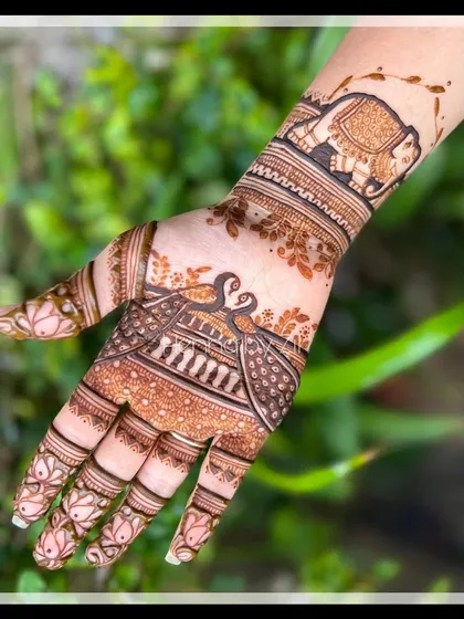A beautiful close-up of a design featuring peacocks and elephants, perfect for a traditional bride.