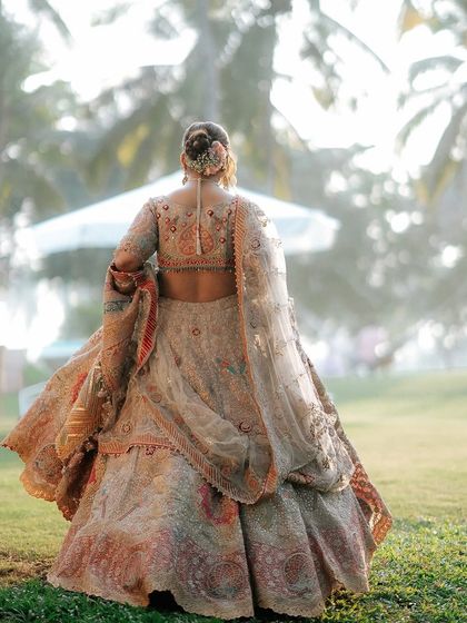 A shot from the back of Khyati's bridal look, showing her elegant bun adorned with a delicate accessory. The hairstyle perfectly complements the regal feel of her Rimple and Harpreet lehenga.