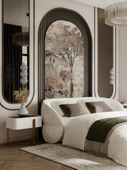 This artistic bedroom design features a unique arched headboard with a nature-inspired mural. The curved forms are echoed in the bed frame and mirrors, creating a soft and elegant aesthetic with a statement chandelier overhead.