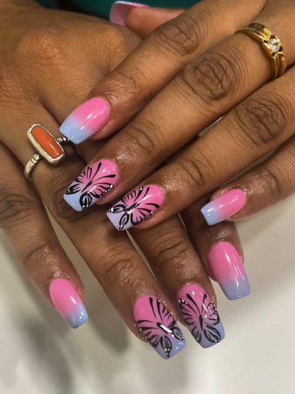 A still image of the pink and blue ombre nails with butterfly art, giving a closer look at the detail in the linework and the smoothness of the color transition.