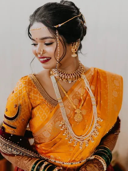 A close-up of the bride's traditional jewelry and the details of her makeup.
