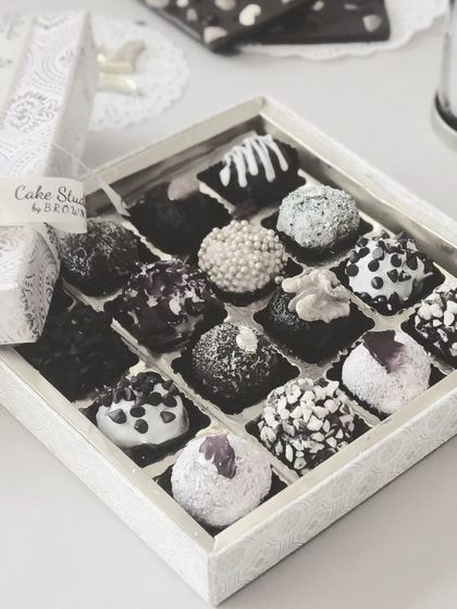 This elegant white and silver box of assorted chocolate truffles is perfect for sophisticated gifting. The monochrome theme with varied textures makes it a visually stunning and delicious present.