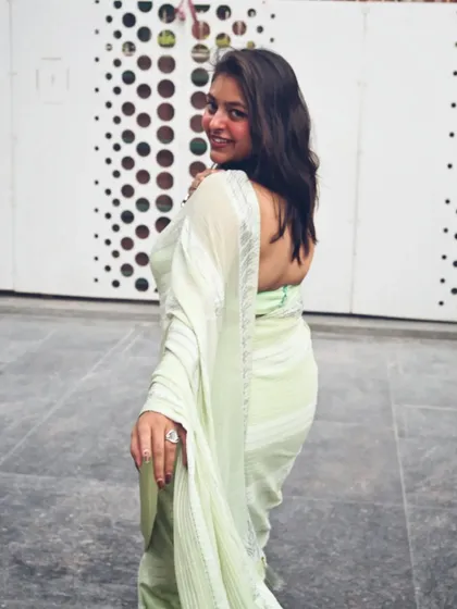 A classic over-the-shoulder pose to show off the back of the saree and the overall look. It's all about the details.