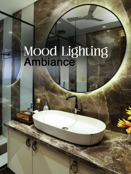 Mood lighting and ambiance are critical. Here, a backlit circular mirror and rich, dark marble walls create a dramatic and sophisticated atmosphere in the powder room.