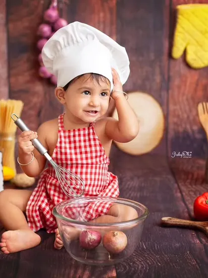 A moment of pure concentration while mixing up some onions. It's these funny and unexpected moments that make every baby chef photoshoot unique and full of laughter.
