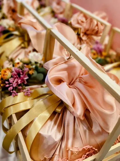 Beautifully curated hampers in pinewood crates with satin-wrapped gifts, prepared for Hindustan Unilever and Lakme. The peach and gold color scheme creates a soft and luxurious feel.