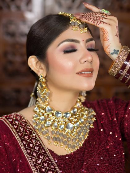 A close-up showcasing the soft smokey eye and nude lipstick. This is a great choice for brides who want a modern touch with their traditional maroon outfit.