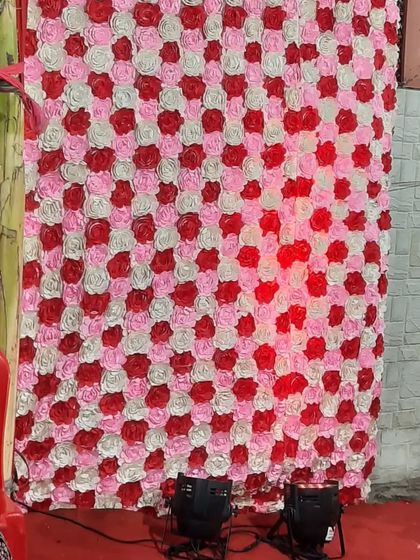 A flower wall backdrop being illuminated by two of my floor-level PAR can lights. This technique, known as uplighting, adds depth and color to any decor element.