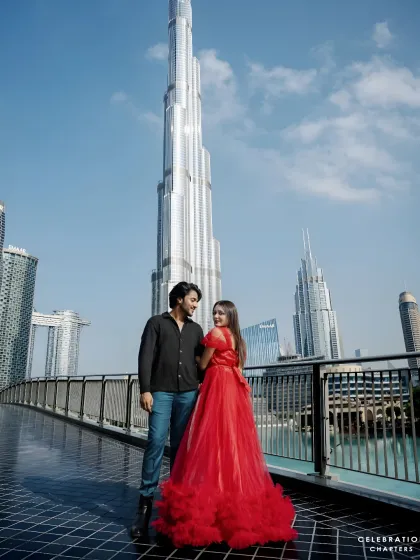 Our rental gowns are perfect for destination photoshoots. This couple chose a bold red ruffled dress for their session in Dubai, standing out against the iconic city skyline.