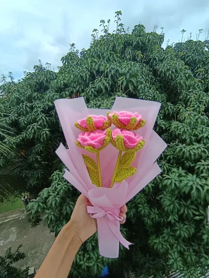 A simple bouquet of four pink roses, elegantly wrapped.