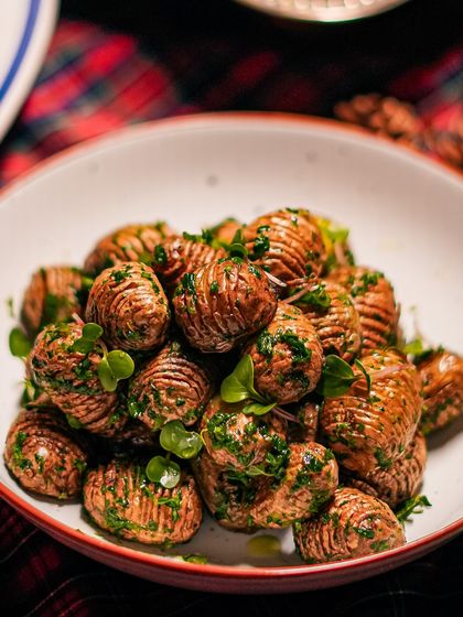 A bowl of our herbed Hasselback potatoes, a delicious side dish from our special Christmas menu, perfect for any festive feast.