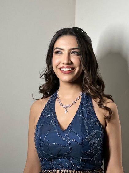 A happy, smiling portrait of the bride in her blue Sangeet lehenga.