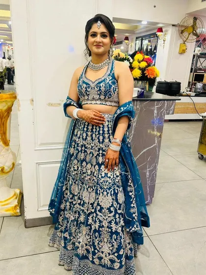 Another client looking gorgeous in the same peacock blue rental lehenga. The halter neck and intricate work make it a flattering choice for festive occasions.