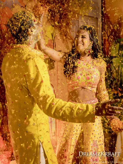 A playful and messy moment during the Haldi, with the couple covered in flowers and turmeric. These are the fun, candid memories that families will cherish forever.