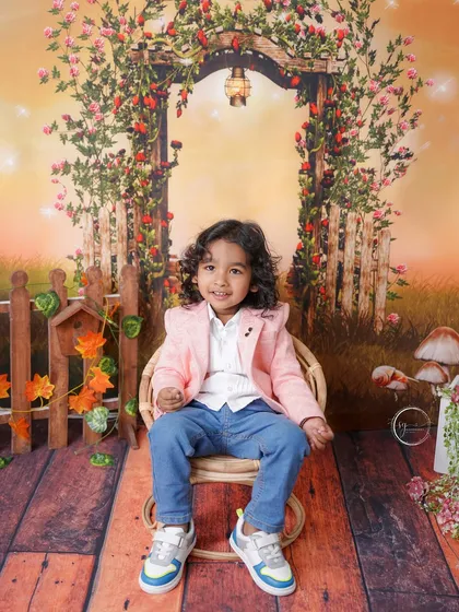 This charming two-year-old is dressed in a stylish pink blazer for his enchanted garden photoshoot.
