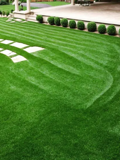 A large lawn with creative, wave-like mowing patterns. This technique adds a sense of movement and artistry to an open expanse of grass.