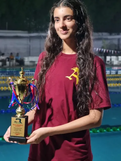 Veera Prathambir holding her trophy after securing 5 medals, including 3 golds, at the CBSE North Zone swim meet. Her gold and personal best in the 200m Individual Medley, a new event for her, shows her versatility.