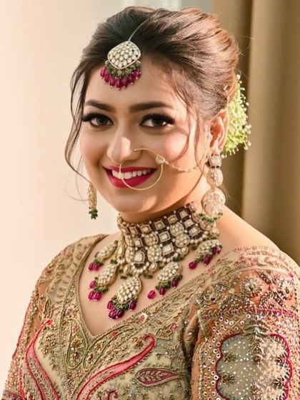 The happy smile of a #BrideOfMohraya. She looks radiant in a pachi kundan choker set with ruby-colored accents, paired with a matching maang tikka and nath.