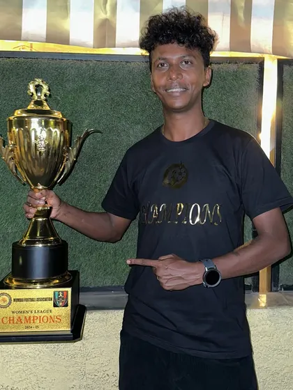 Our coach with the MFA Women's Premier League trophy, a symbol of a perfect, undefeated season.