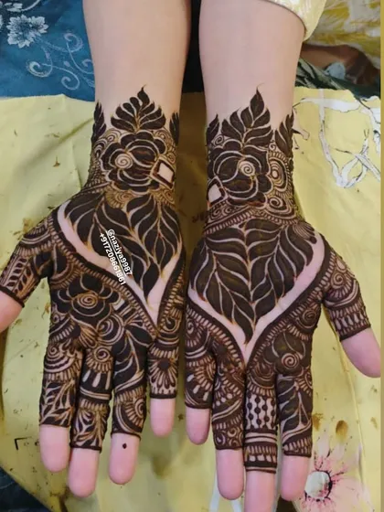 This design features a heart-shaped gap in the center of the palm, a popular element in modern Gulf henna. The leafy patterns create a beautiful frame.