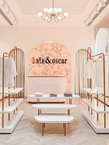 A full view of the Kate & Oscar boutique, showing how all the custom-designed furniture, from the racks to the reception desk with its floral backdrop, creates a cohesive and magical shopping experience.