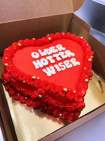 August babies be like: "Older, Hotter, Wiser". This fiery red heart-shaped vintage cake with gold pearl details is perfect for a summer birthday celebration.
