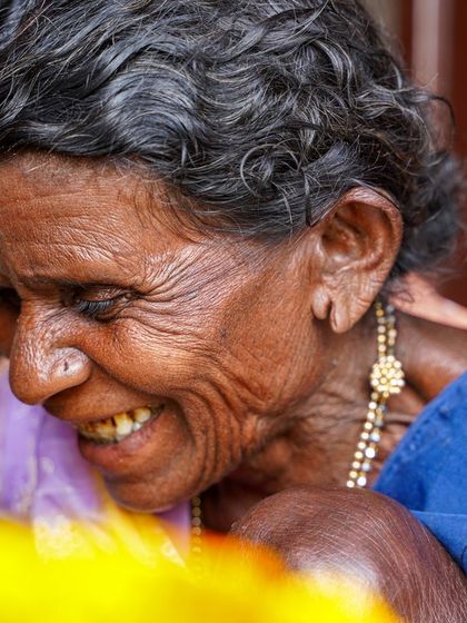 A close-up portrait capturing a soft, downward glance. The focus is on the 'aaji's' expression, filled with a gentle warmth that makes this image incredibly touching and real.