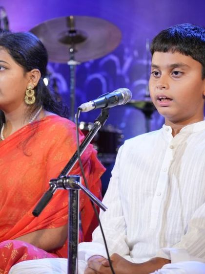 Two students, one senior and one junior, sing side-by-side, reflecting our multi-age group class structure.