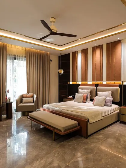 This master bedroom features a striking accent wall with vertical panels of wood and leather. The warm, integrated lighting and luxurious marble-like flooring create a sophisticated and modern retreat.