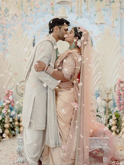 A kiss to seal the deal, with a shower of petals all around. This photo captures the peak emotional moment of the ceremony, set against our dreamy, pastel-hued decor.