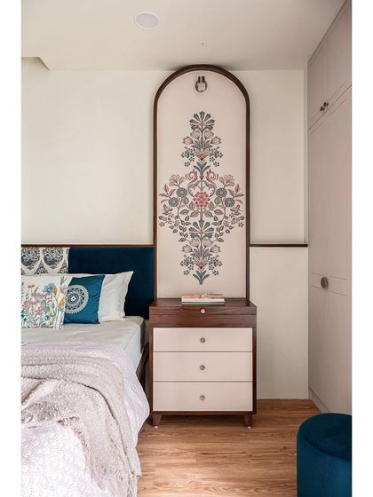 A close-up of the custom mural, which serves as a unique headboard on one side of the bed. The intricate floral design is framed in dark wood, creating a beautiful focal point.