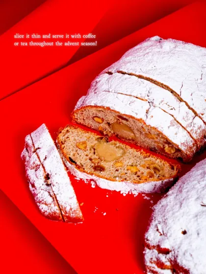 A slice of our traditional German Stollen, a dense, buttery bread studded with rum-soaked fruits, nuts, and a marzipan core.