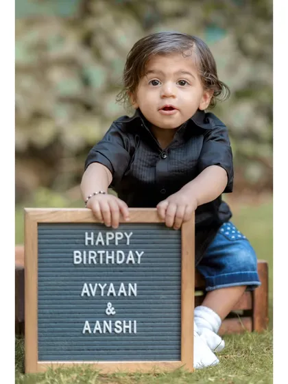 Announcing the big day for twins Avyaan and Aanshi. This charming portrait features one of the twins holding a letterboard with their birthday message, a great way to personalize a shoot.
