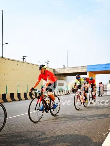 The elite peloton, with a support car in the background, highlighting the professional setup of our races.