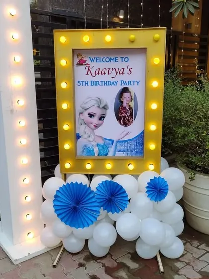 A 'Frozen' themed welcome sign for Kaavya's 5th birthday, with a light-up frame and character art.
