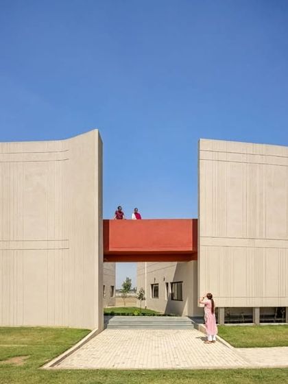 The design of the SMBV school is a direct response to the local climate. The tall, curved walls act as a barrier against strong winds, while the gap between them, connected by a bridge, channels a gentler breeze through the campus.